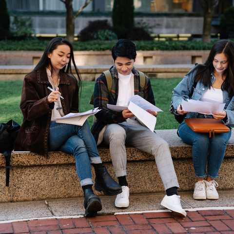 Three students reviewing paperwork together, London 2017